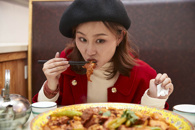 在餐厅吃美味新疆大盘鸡的亚洲少女图片