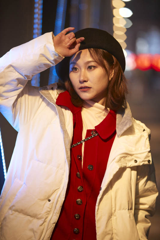 夜晚在繁华灯火的街头拍照的亚洲少女图片