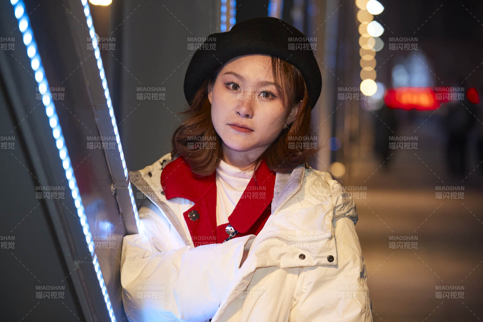 夜晚在繁华灯火的街头拍照的亚洲少女图片