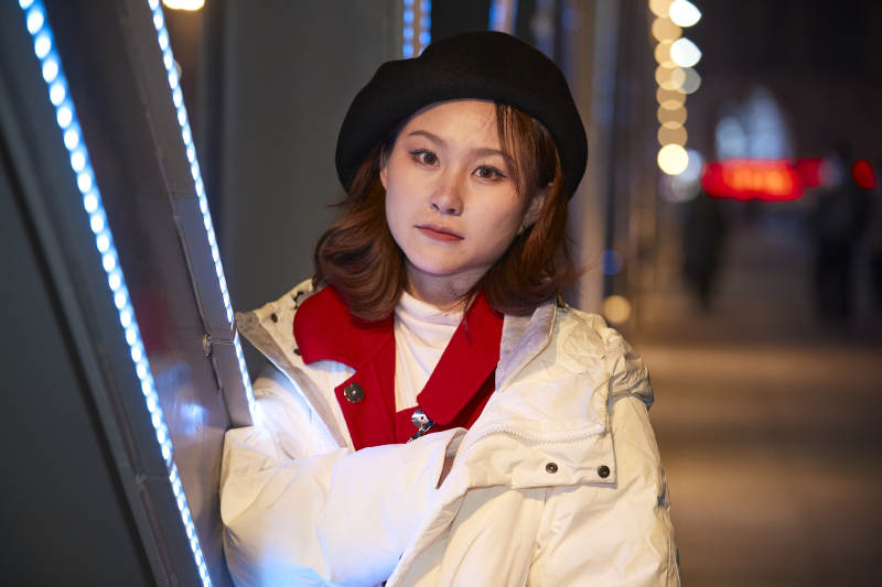 夜晚在繁华灯火的街头拍照的亚洲少女图片