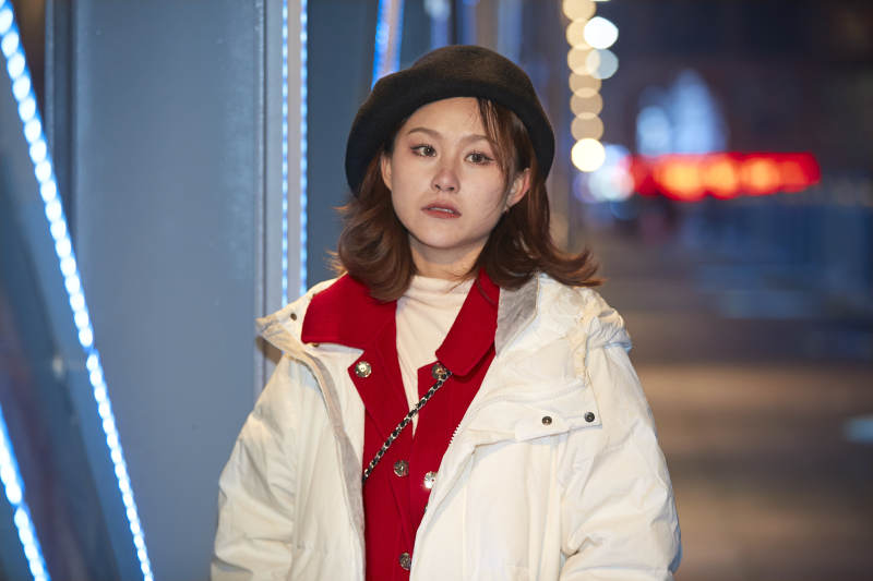 夜晚在繁华灯火的街头拍照的亚洲少女图片