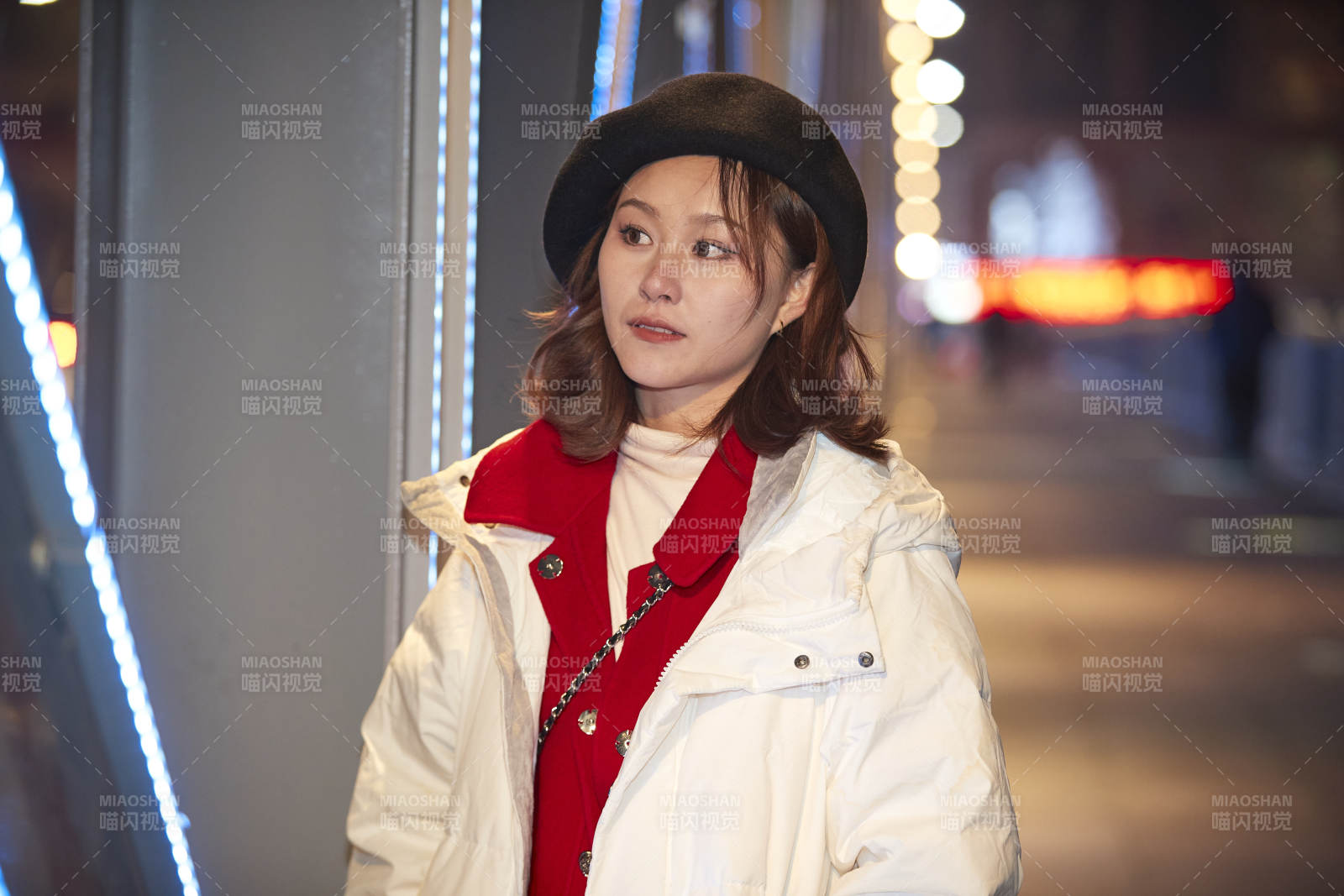 夜晚在繁华灯火的街头拍照的亚洲少女图片