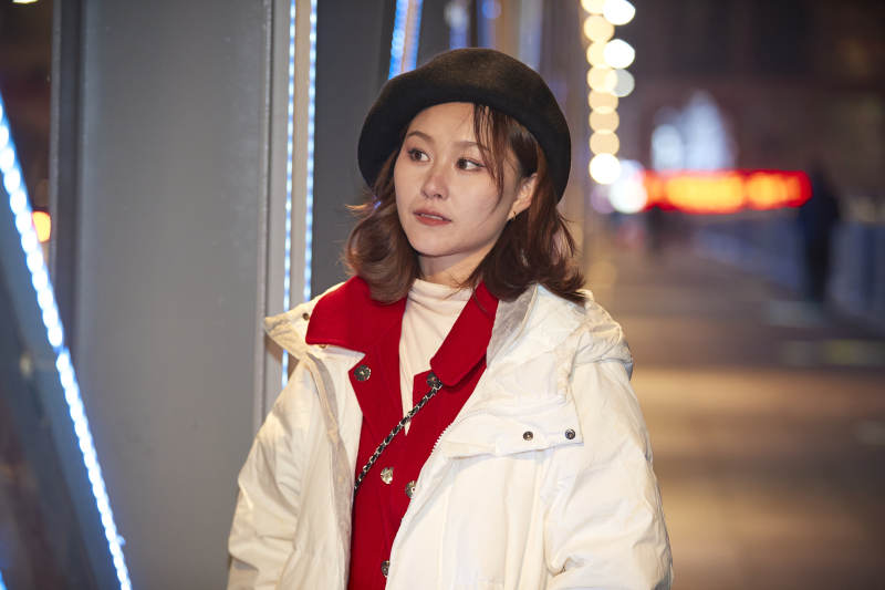 夜晚在繁华灯火的街头拍照的亚洲少女图片