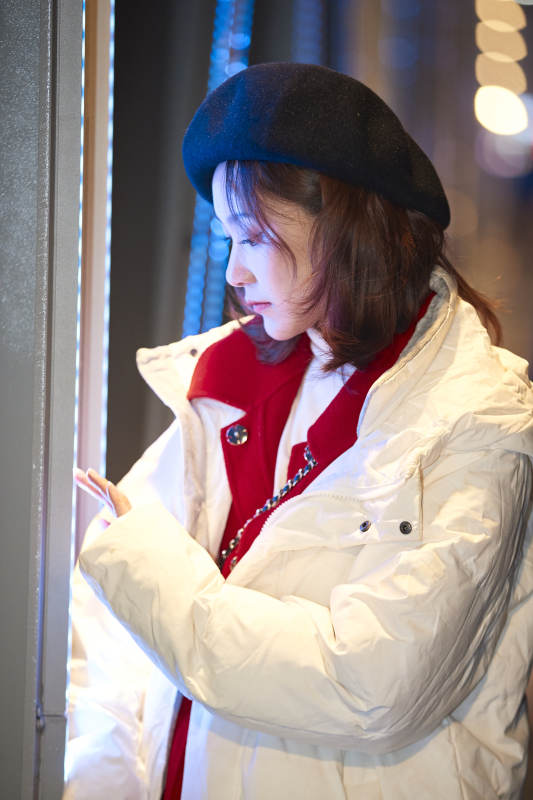 夜晚在繁华灯火的街头拍照的亚洲少女图片