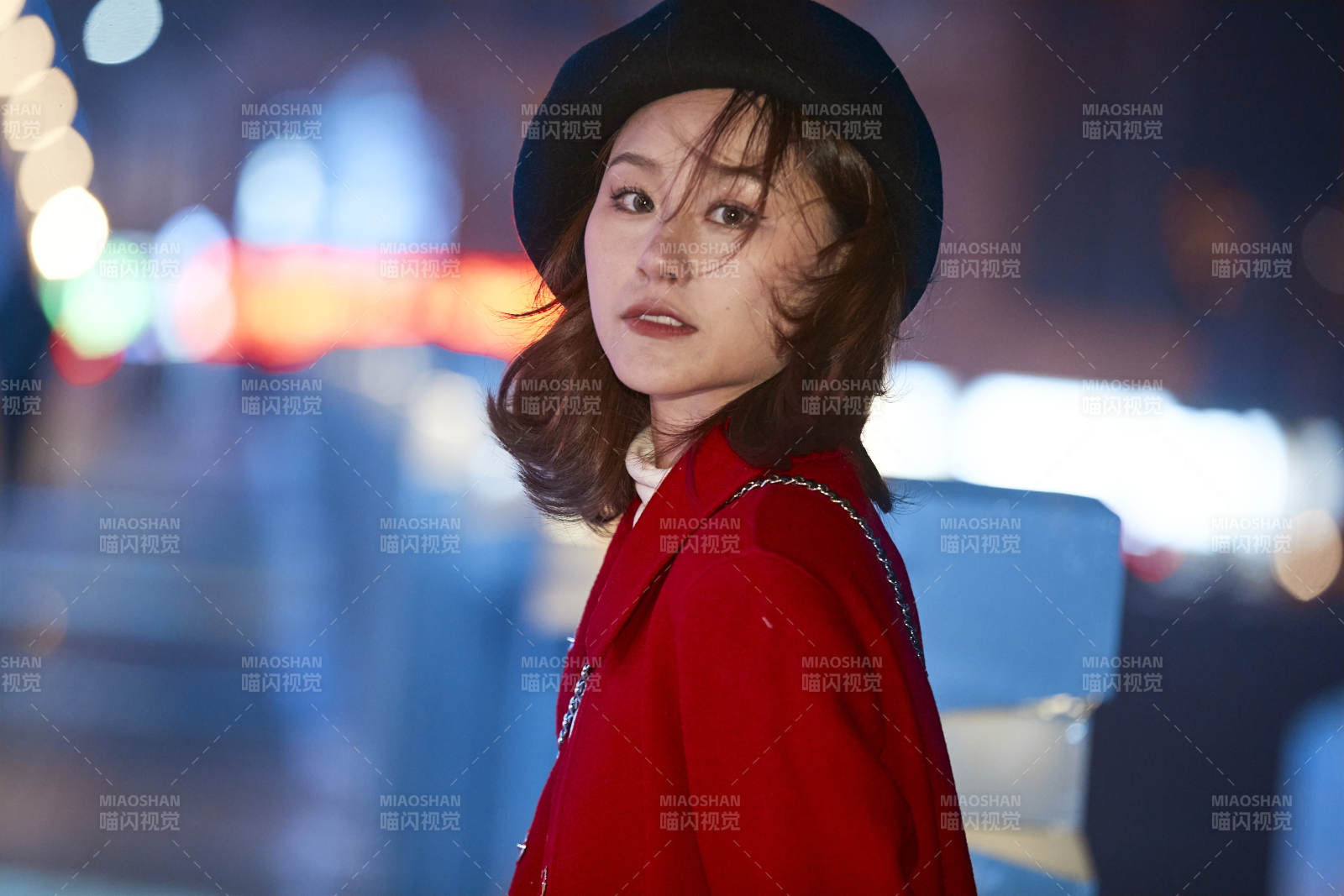 夜晚在繁华灯火的街头拍照的亚洲少女图片