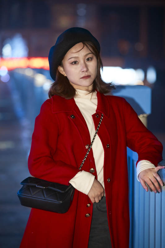 夜晚在繁华灯火的街头拍照的亚洲少女图片