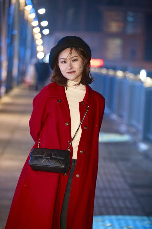 夜晚在繁华灯火的街头拍照的亚洲少女图片