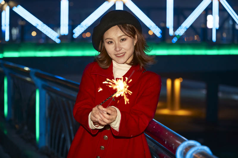 夜晚燃放仙女棒的可爱亚洲少女图片