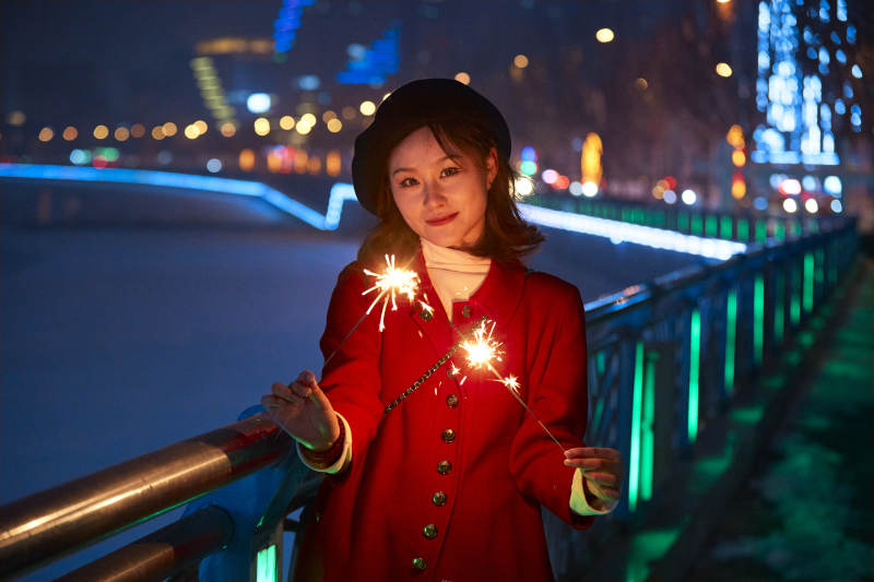 夜晚燃放仙女棒的可爱亚洲少女图片