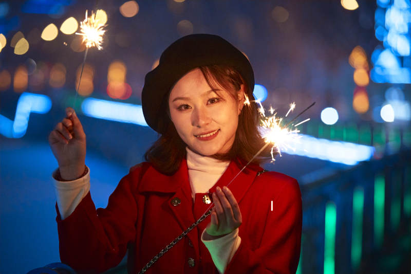 夜晚燃放仙女棒的可爱亚洲少女图片