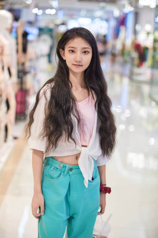 假日悠闲逛商场服装区的中国少女图片