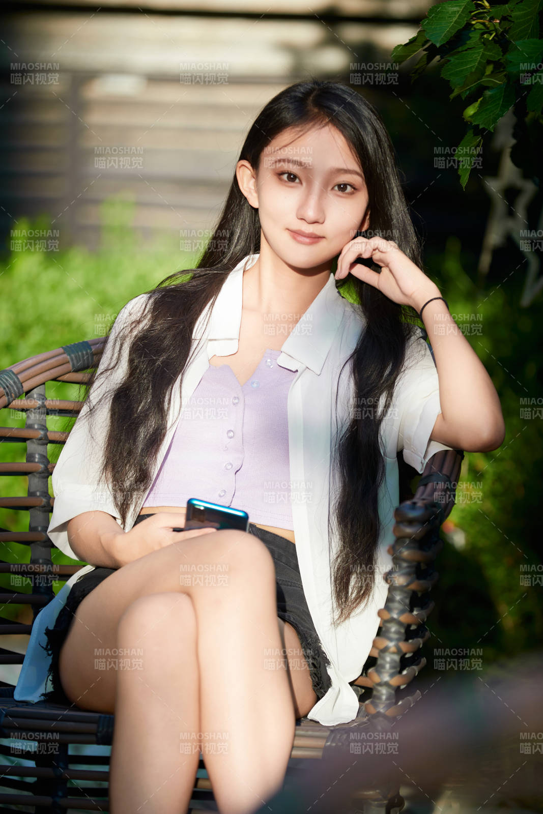 夕阳下在庭院休息拍照的亚洲少女图片