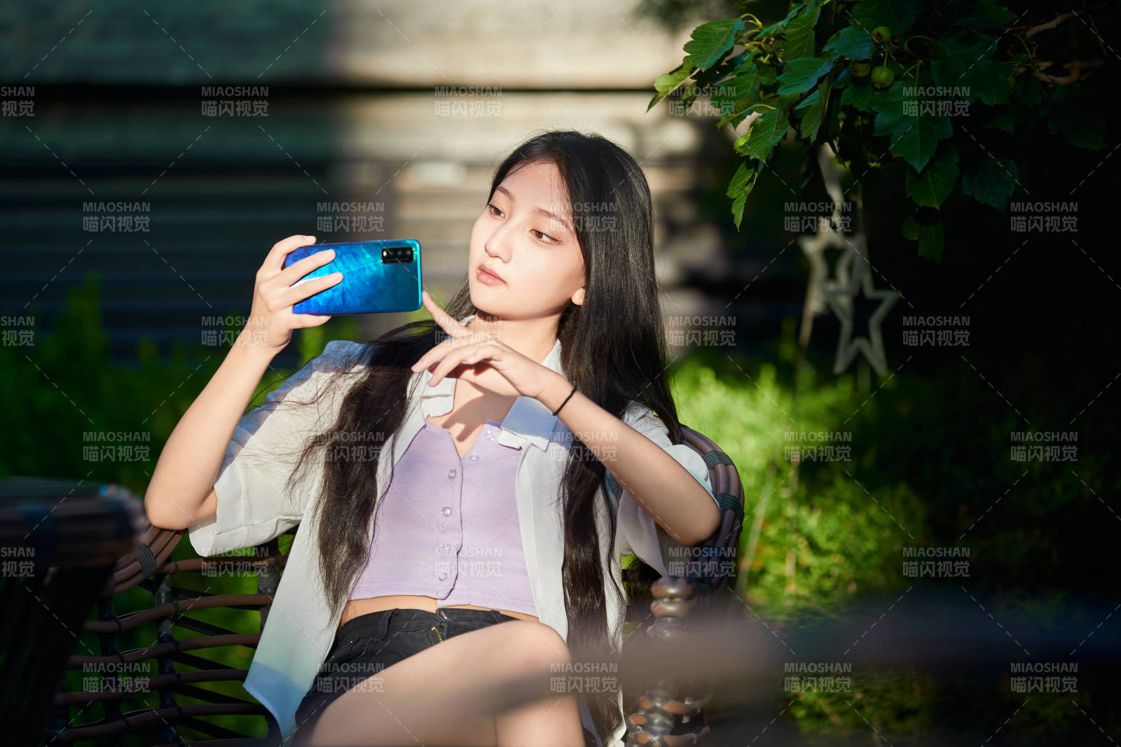 夕阳下在庭院休息拍照的亚洲少女图片