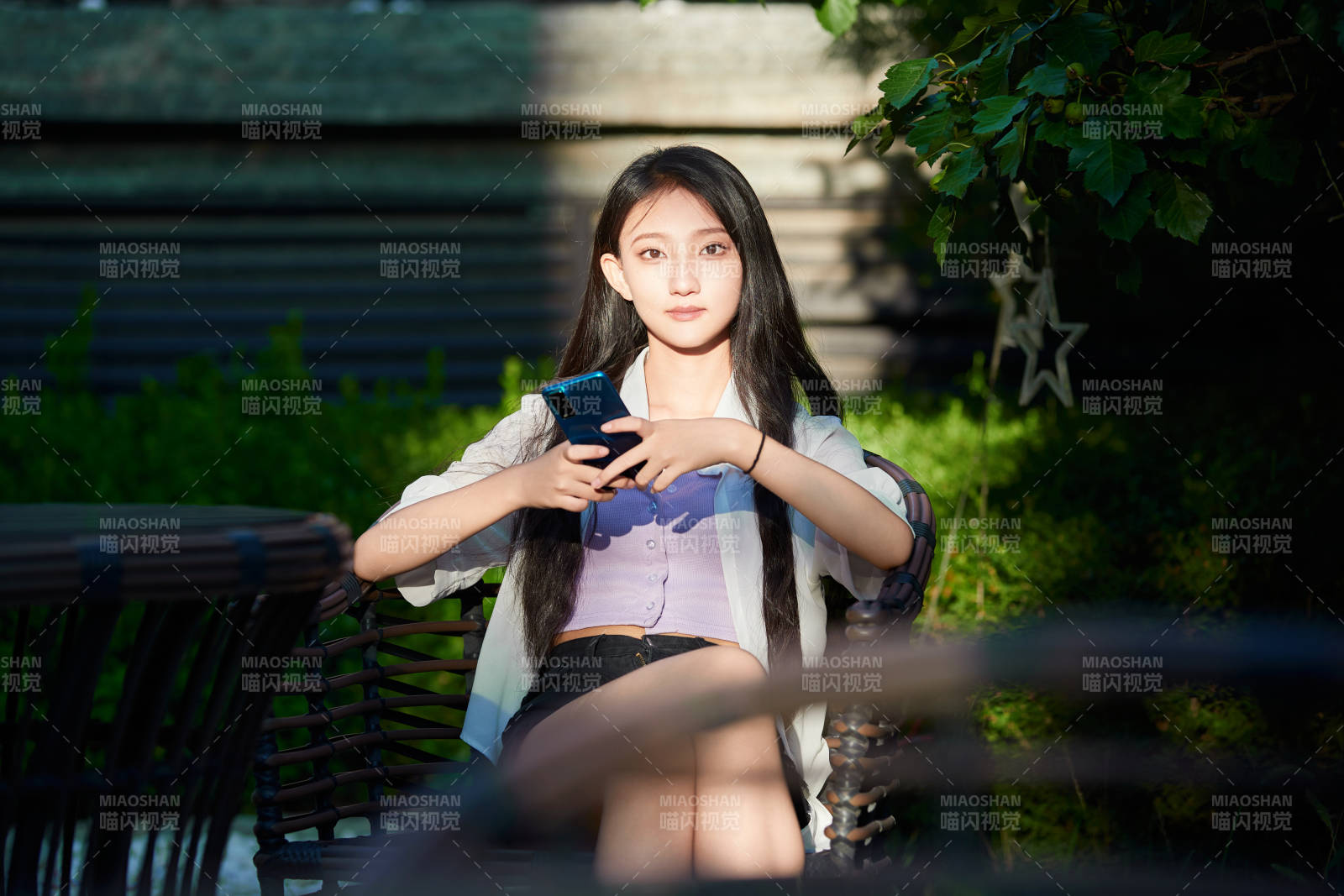 夕阳下在庭院休息拍照的亚洲少女图片