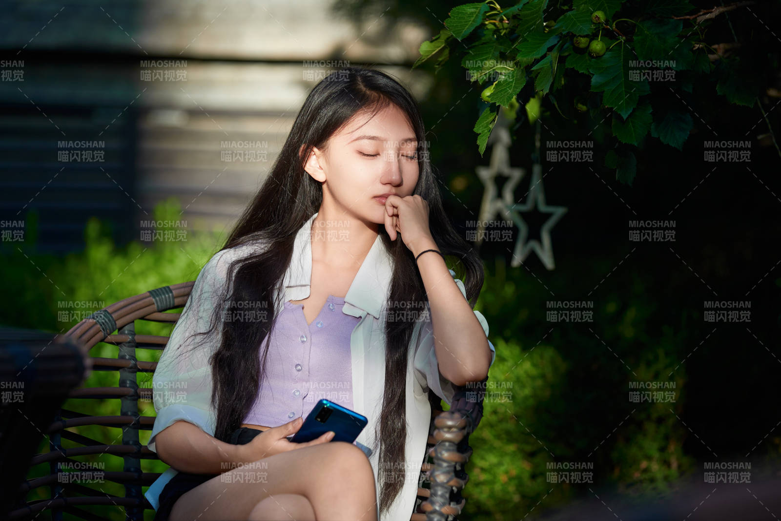 夕阳下在庭院休息拍照的亚洲少女图片