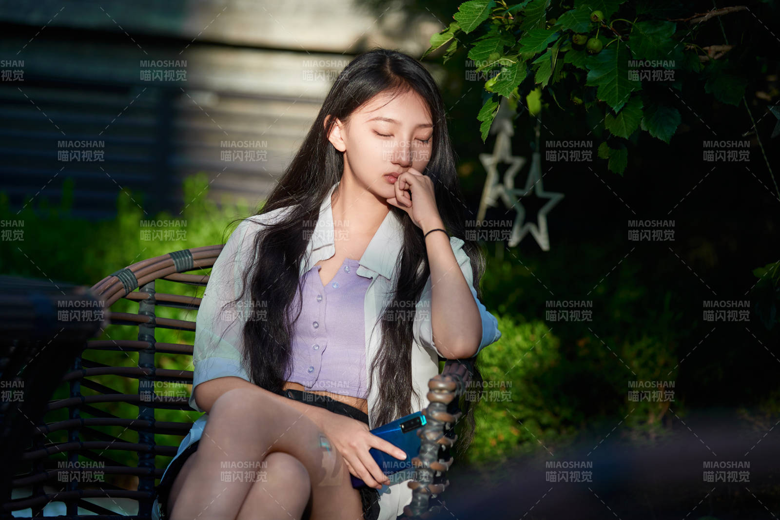 夕阳下在庭院休息拍照的亚洲少女图片