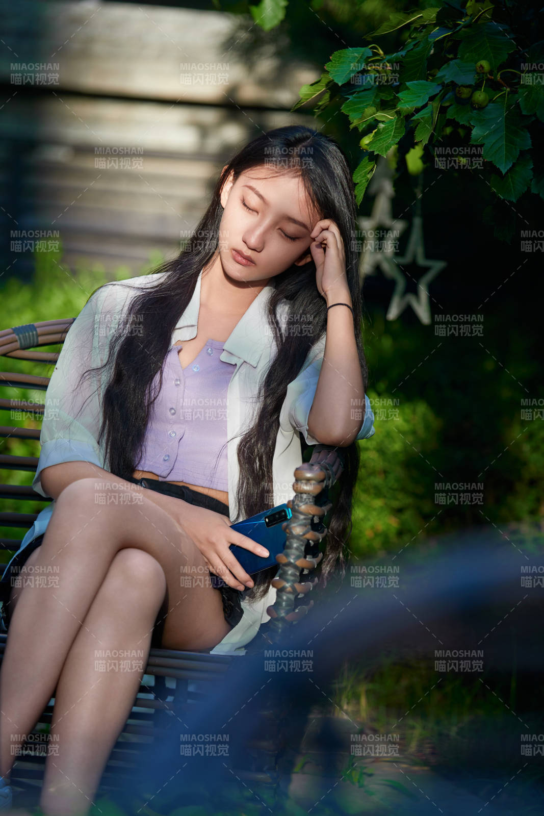 夕阳下在庭院休息拍照的亚洲少女图片