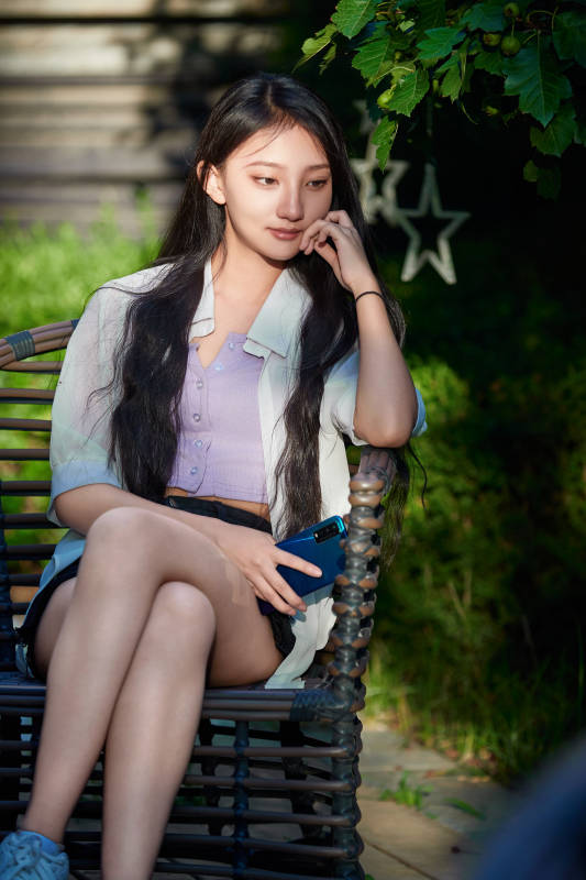 夕阳下在庭院休息拍照的亚洲少女图片