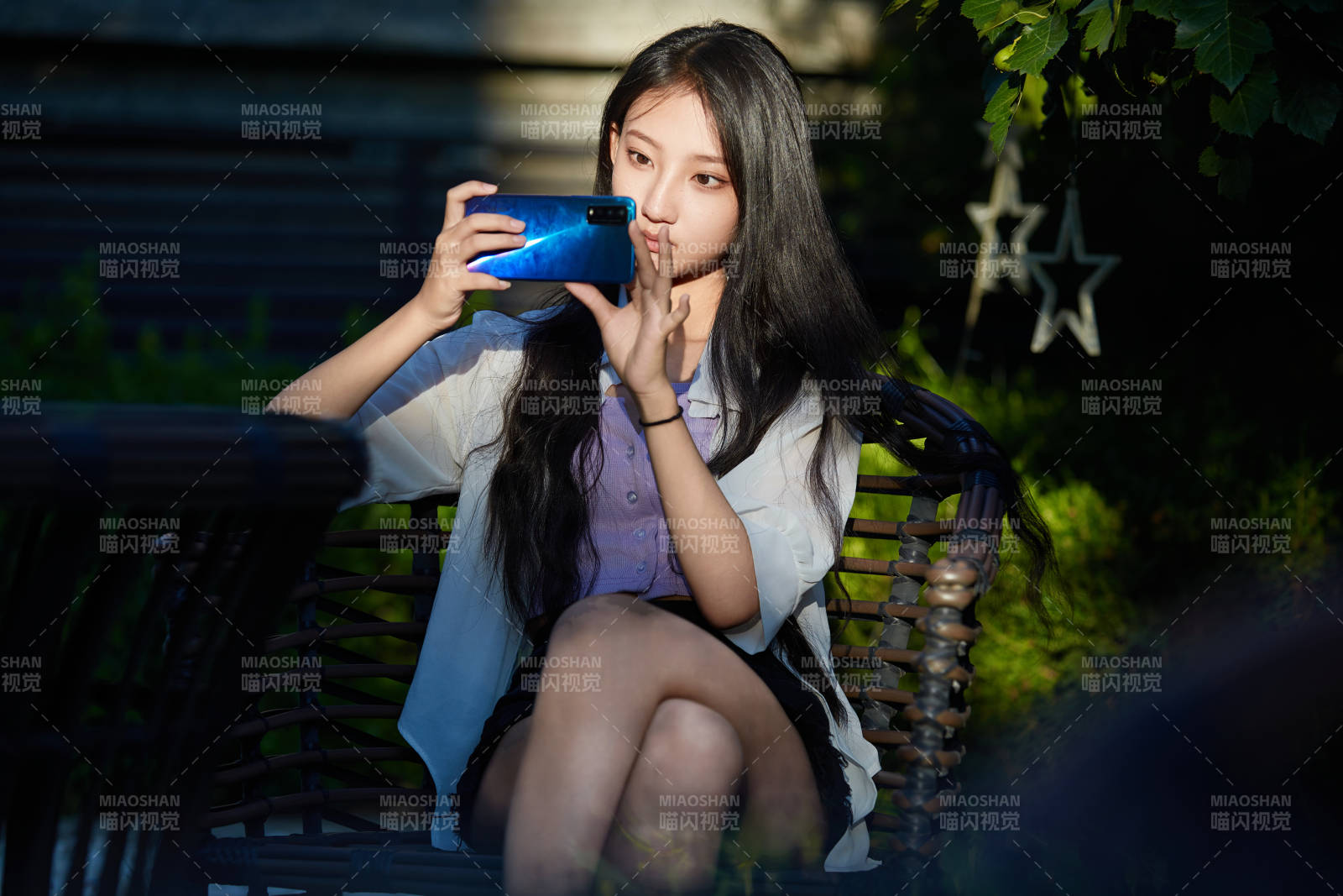 夕阳下在庭院休息拍照的亚洲少女图片