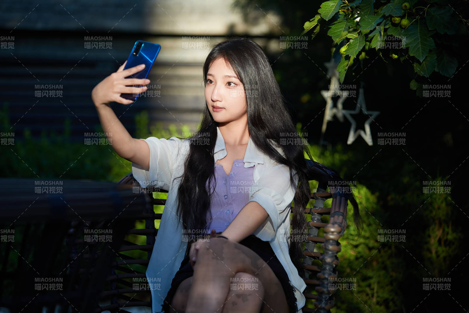 夕阳下在庭院休息拍照的亚洲少女图片