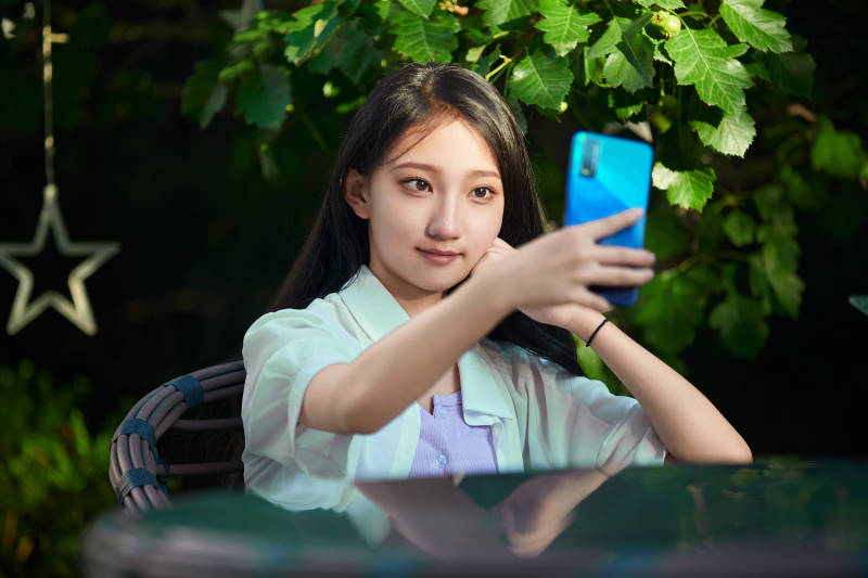 夕阳下在庭院休息拍照的亚洲少女图片