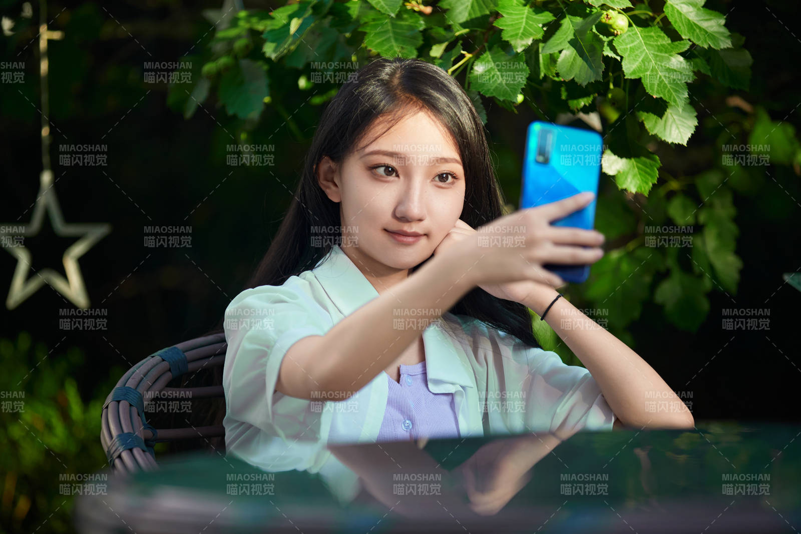 夕阳下在庭院休息拍照的亚洲少女图片