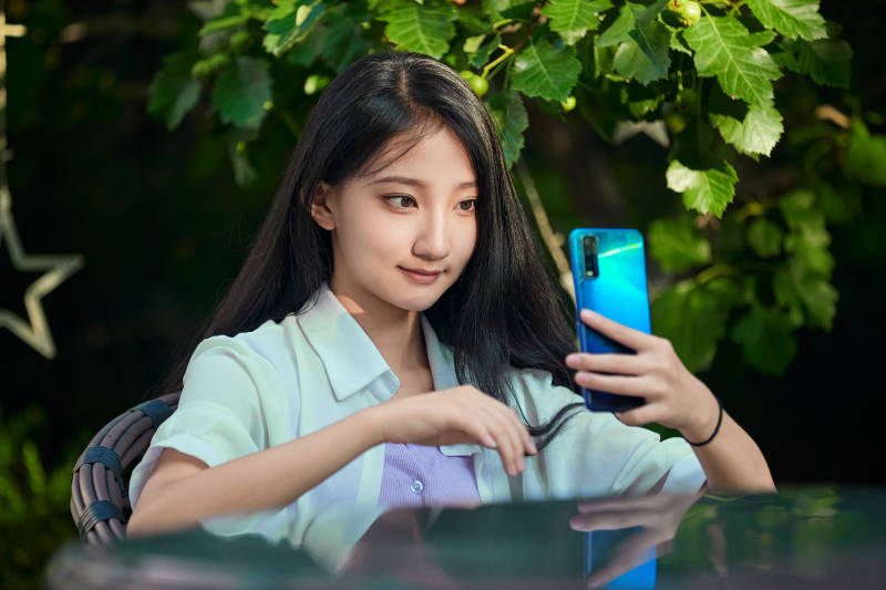 夕阳下在庭院休息拍照的亚洲少女图片