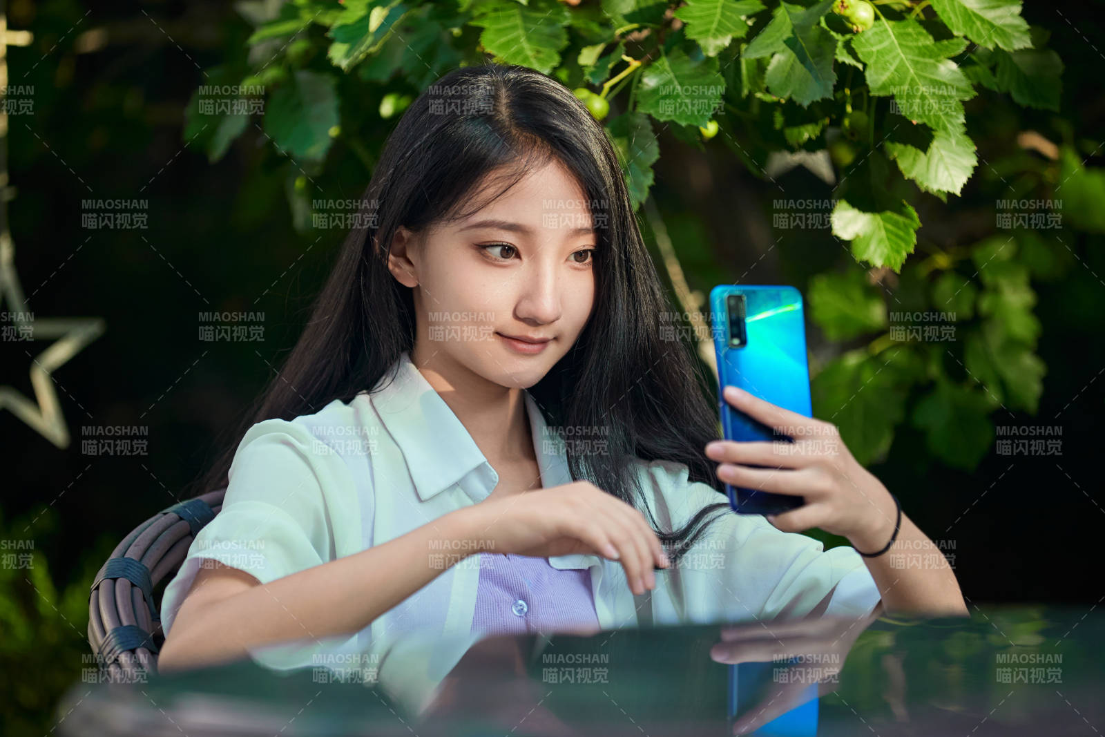 夕阳下在庭院休息拍照的亚洲少女图片