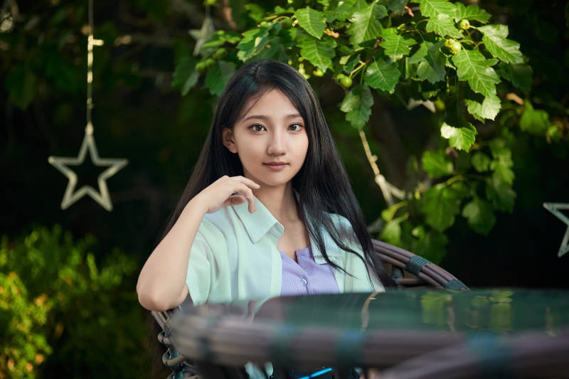 夕阳下在庭院休息拍照的亚洲少女图片