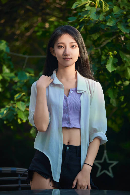 夕阳下在庭院休息拍照的亚洲少女图片