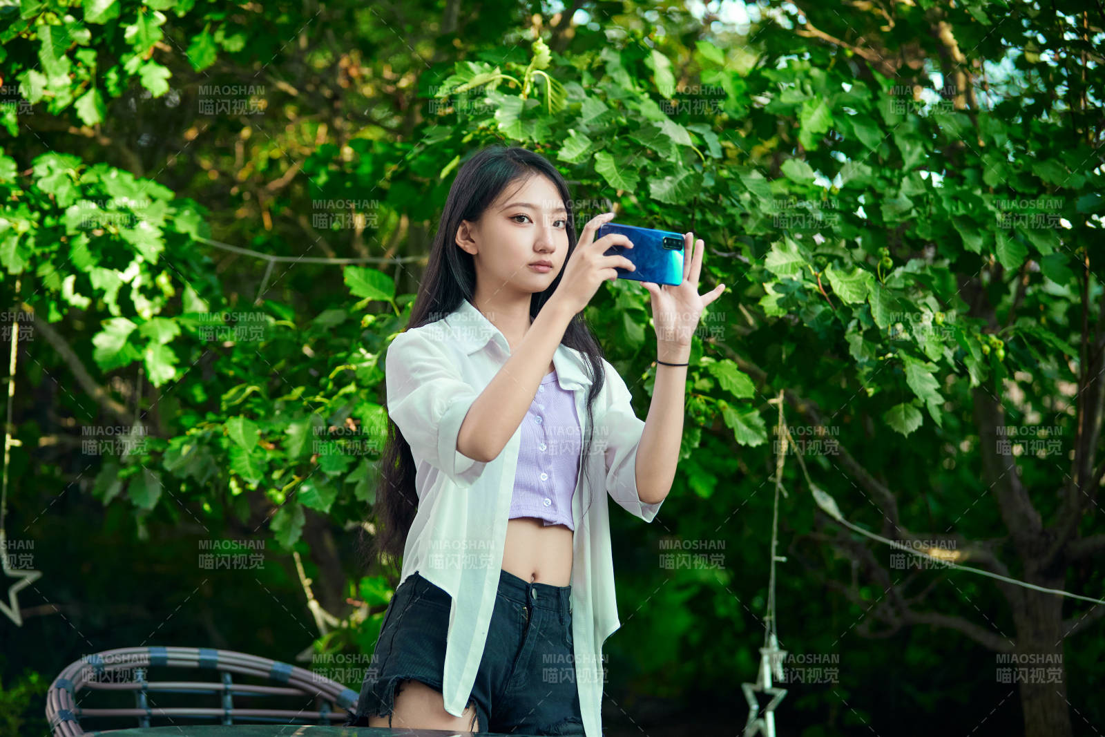 夕阳下在庭院休息拍照的亚洲少女图片