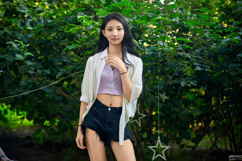 夕阳下在庭院休息拍照的亚洲少女图片