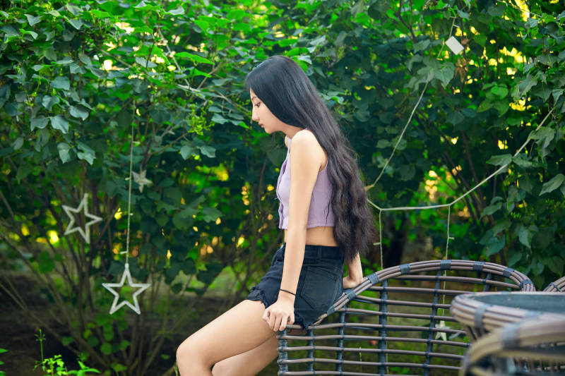 夕阳下在庭院休息拍照的亚洲少女图片