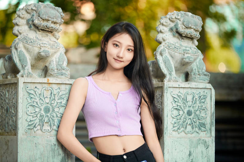 夕阳下在庭院休息拍照的亚洲少女图片