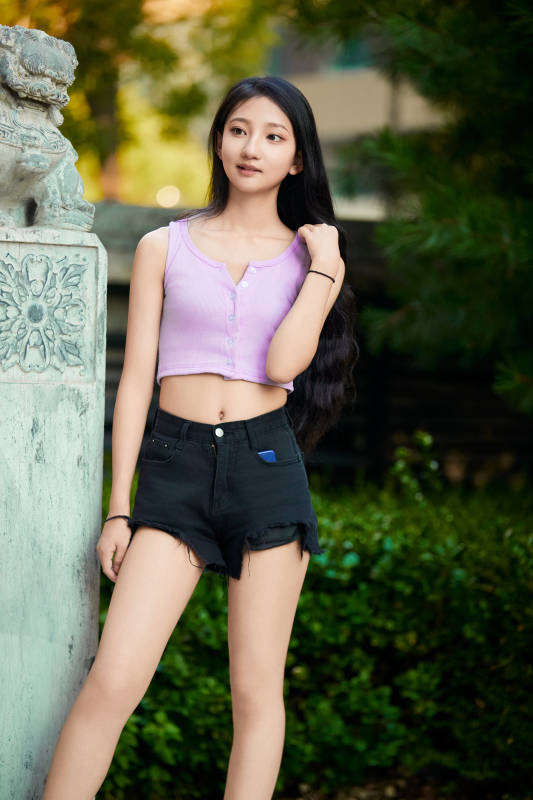 夕阳下在庭院休息拍照的亚洲少女图片