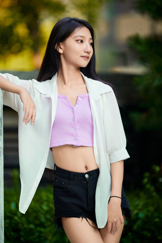 夕阳下在庭院休息拍照的亚洲少女图片