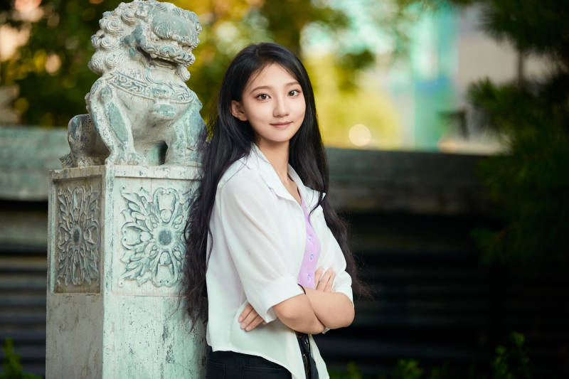 夕阳下在庭院休息拍照的亚洲少女图片