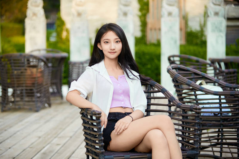 夕阳下在庭院休息拍照的亚洲少女图片