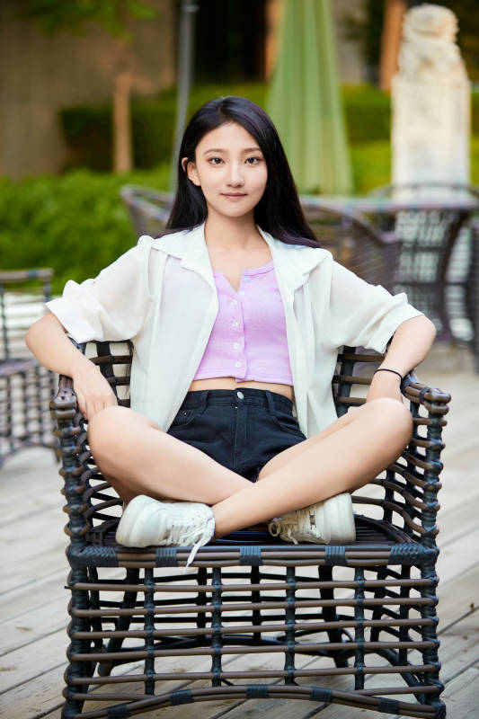 夕阳下在庭院休息拍照的亚洲少女图片