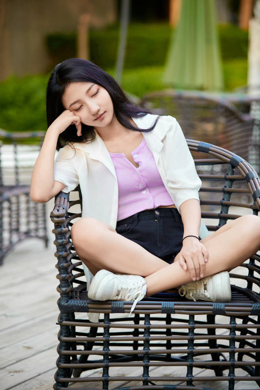 夕阳下在庭院休息拍照的亚洲少女图片