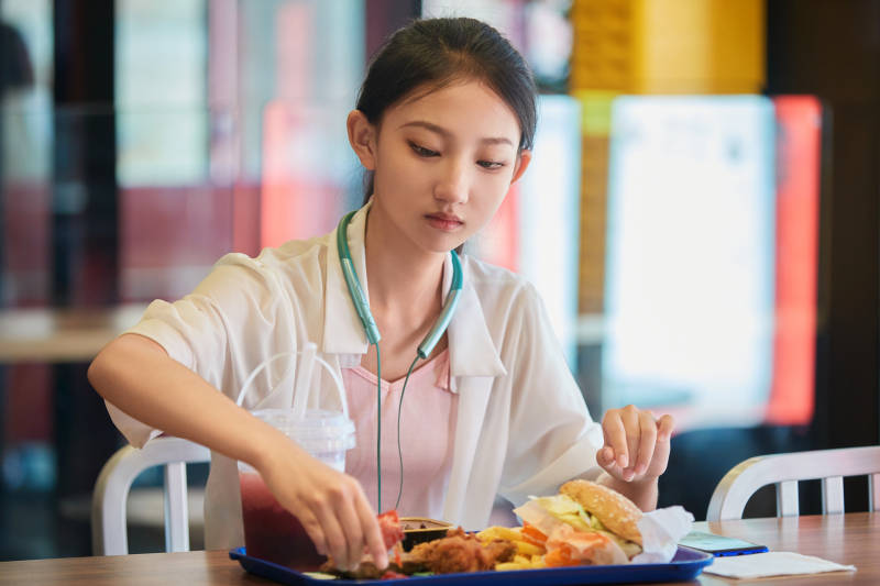 在商场快餐厅大吃特吃的中国可爱少女人像图片