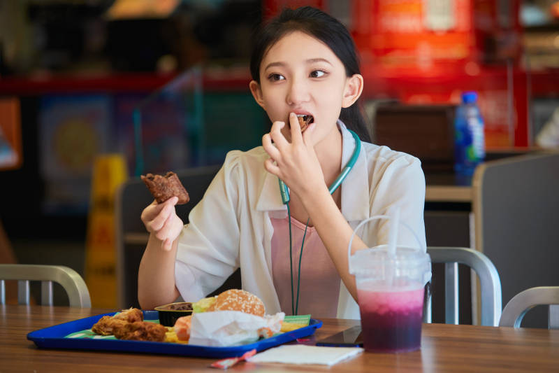 在商场快餐厅大吃特吃的中国可爱少女人像图片