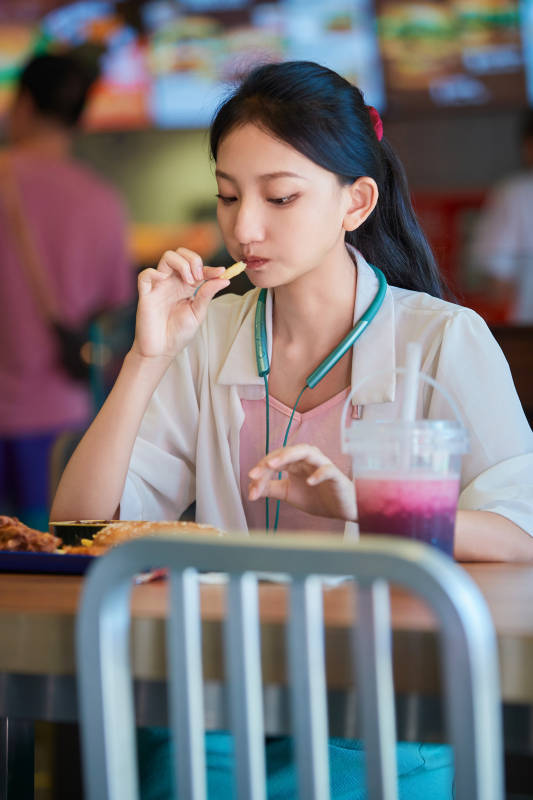 在商场快餐厅大吃特吃的中国可爱少女人像图片
