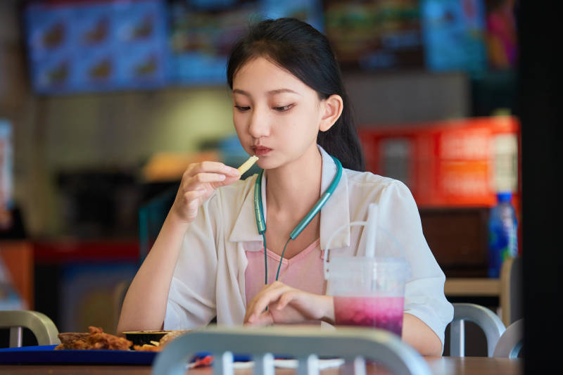 在商场快餐厅大吃特吃的中国可爱少女人像图片