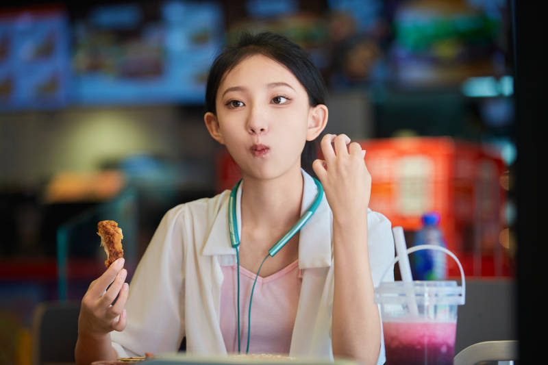 在商场快餐厅大吃特吃的中国可爱少女人像图片