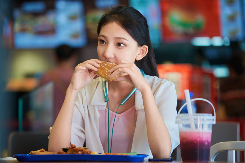在商场快餐厅大吃特吃的中国可爱少女人像图片