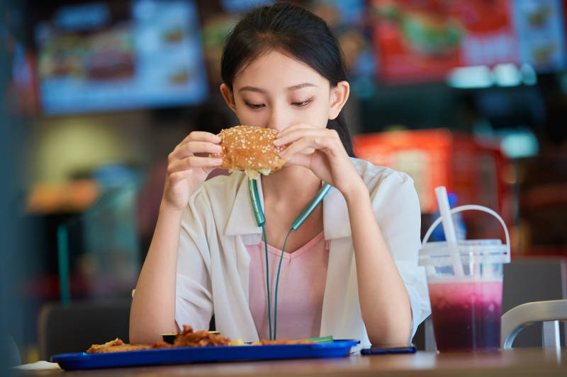 在商场快餐厅大吃特吃的中国可爱少女人像图片
