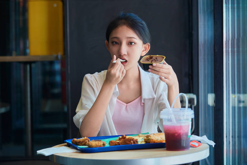 在商场快餐厅大吃特吃的中国可爱少女人像图片