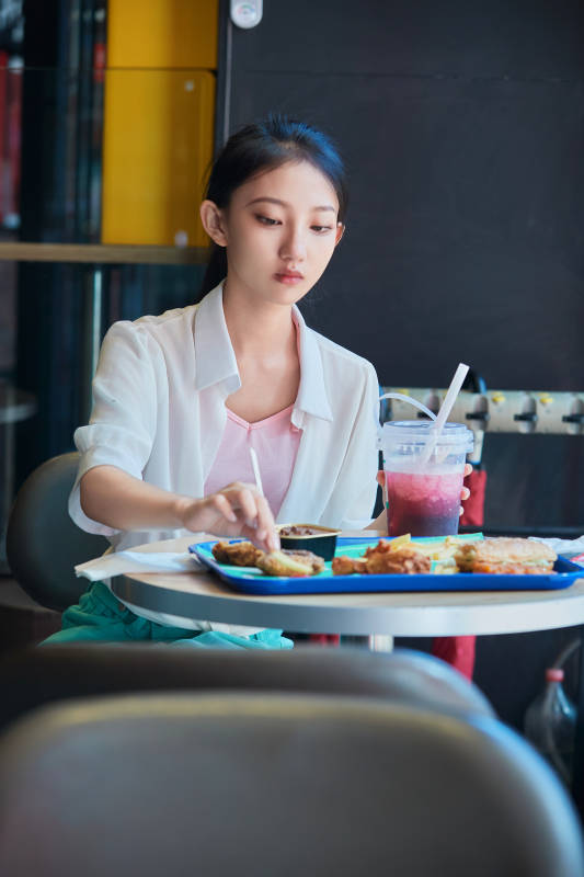 在商场快餐厅大吃特吃的中国可爱少女人像图片