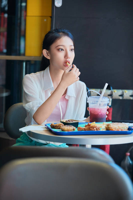 在商场快餐厅大吃特吃的中国可爱少女人像图片
